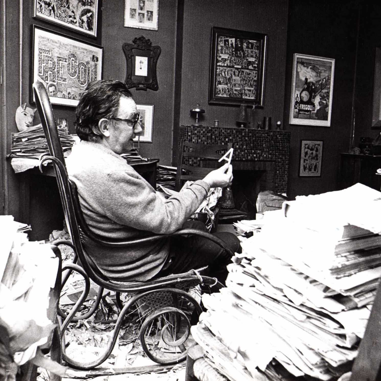 Joan Brossa assegut amb una A a la mà. Pau Barceló, 1974 cedida per la Fundació Joan Brossa